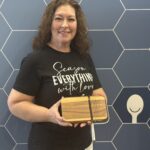 Melanie holding a Pampered Chef cheese slicing board at conference