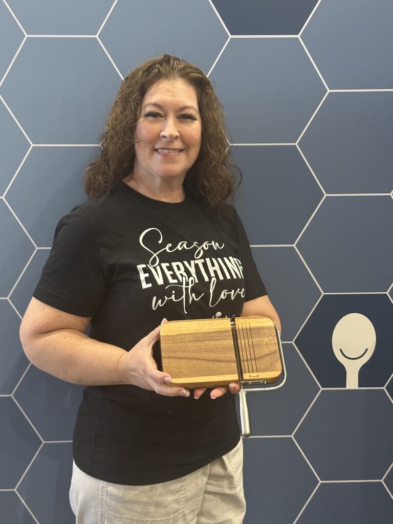Melanie holding a Pampered Chef cheese slicing board at conference