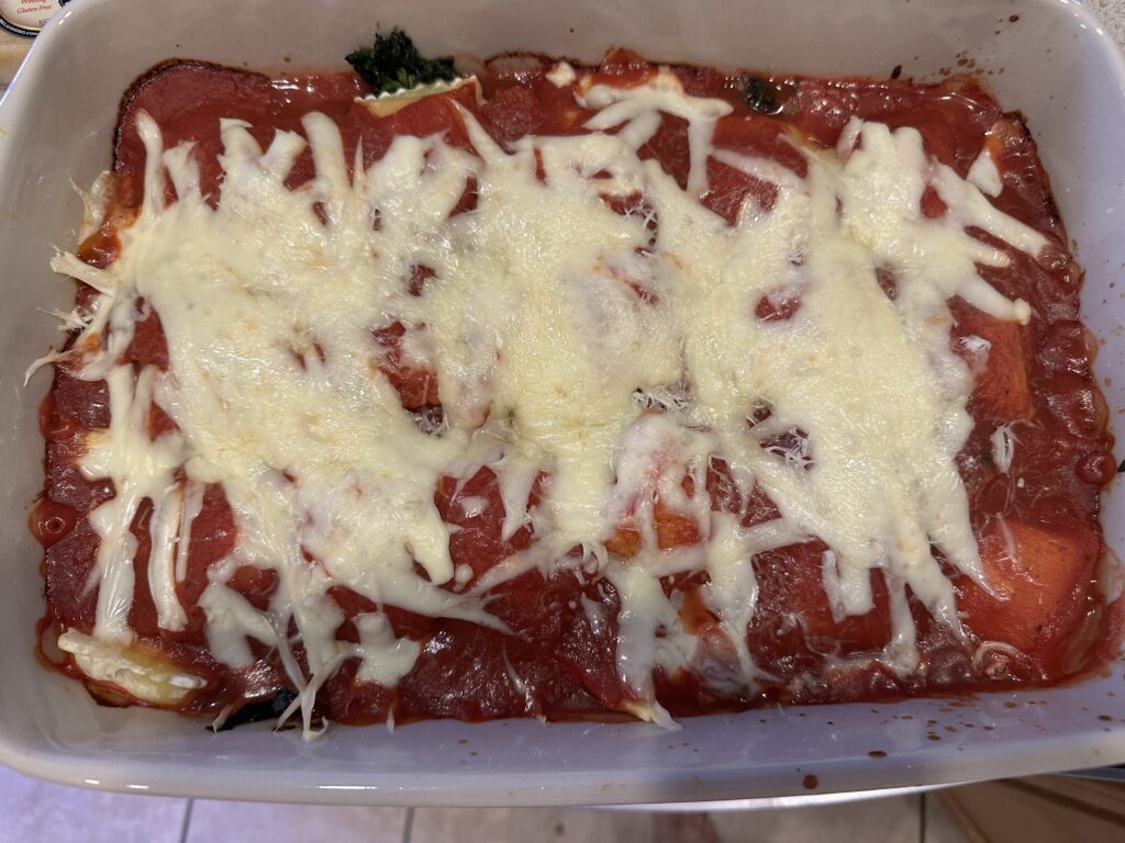 Family-size ravioli lasagna baked in a rectangular stone baker with melted mozzarella cheese on top