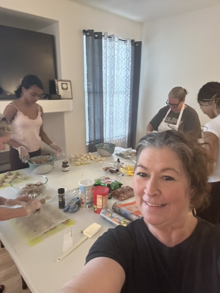 Melanie smiling while participants prepare cookie dough at her Cookie Workshop